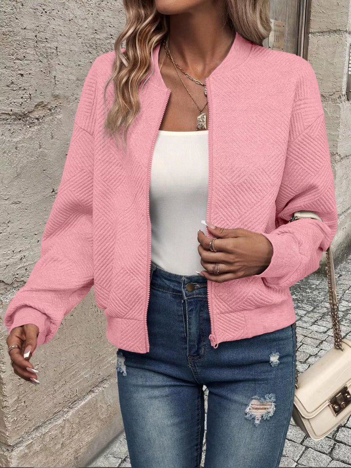 Pink quilted diamond bomber jacket, open front with hand at the hem