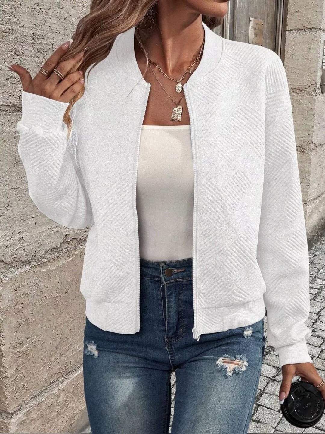 White zip up bomber jacket, open front with hand raised