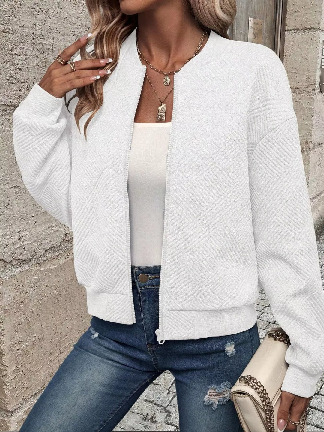 White quilted diamond bomber jacket worn open over a white top