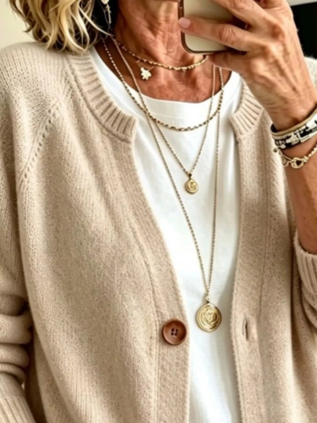 Close-up of the beige cardigan crew neckline and wooden-look button