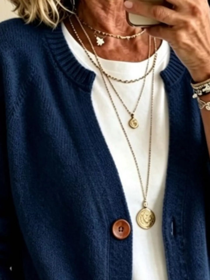 Close-up of the navy cardigan crew neckline and wooden-look button