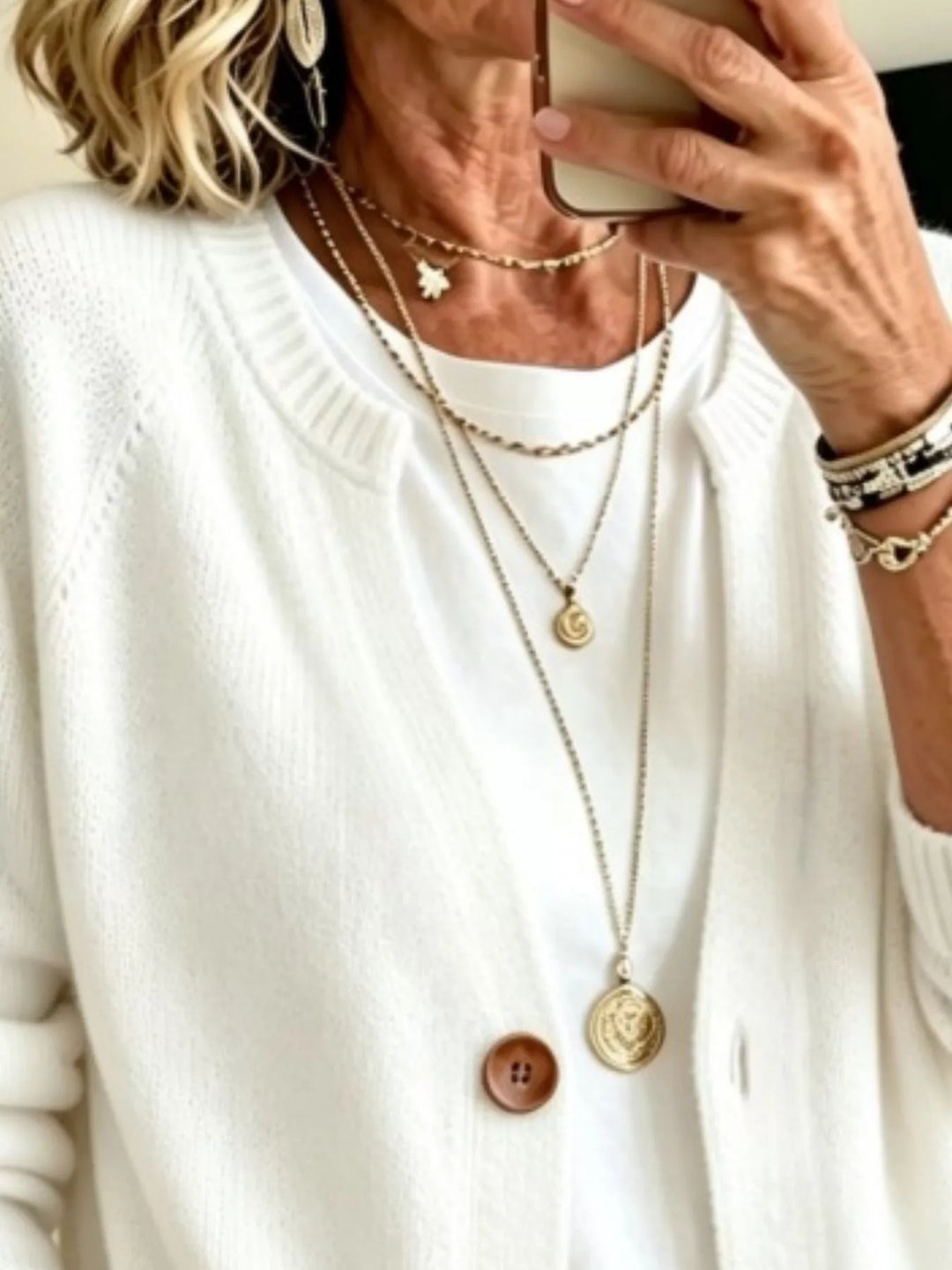 Close-up of the white cardigan crew neckline and wooden-look button