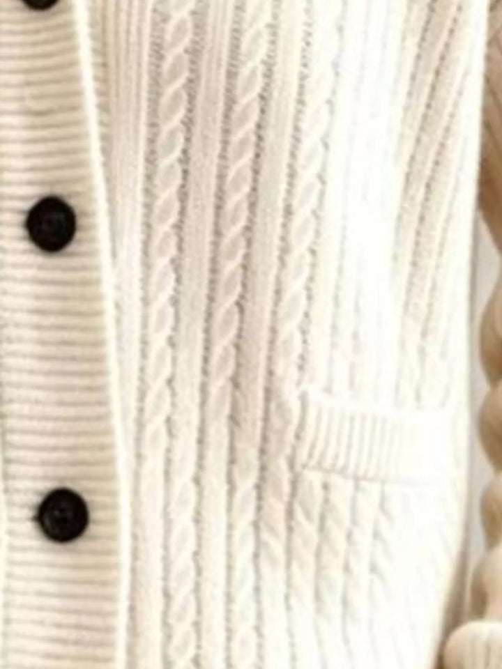 Close-up of ivory cable knit cardigan buttons and patch pocket