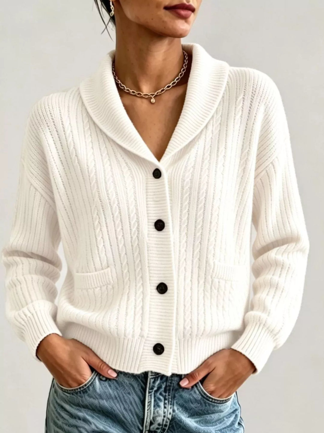 Ivory button up shawl collar cardigan with cable knit, tucked hands in jeans