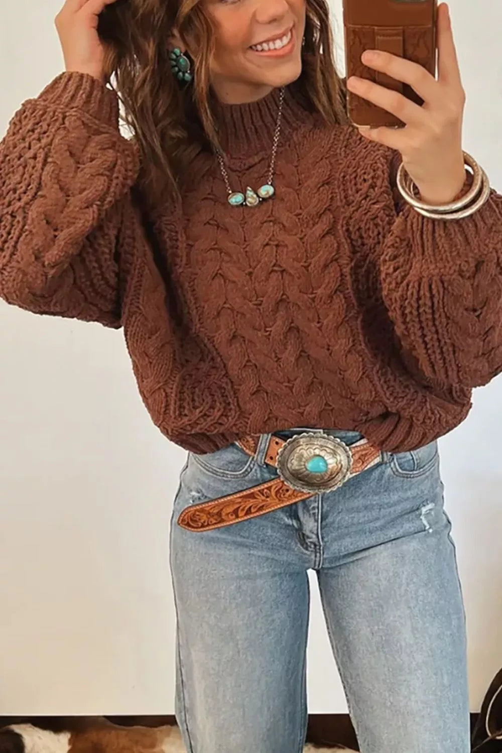 Close-up of the chestnut chunky cable knit sweater with bubble sleeves and a belt