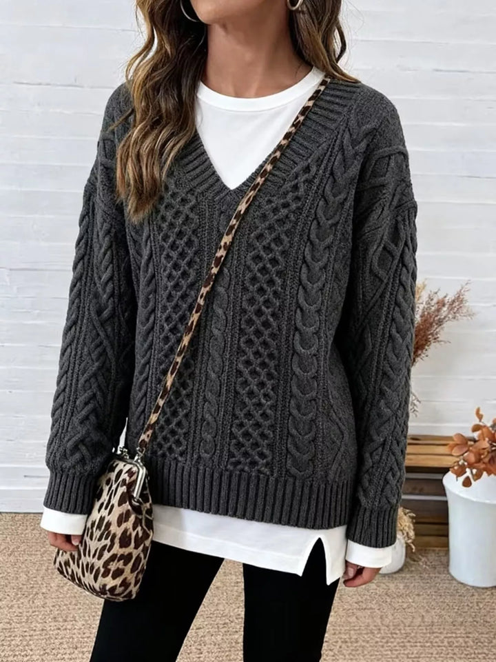 Charcoal oversized cable knit v neck sweater worn with black leggings and a leopard bag
