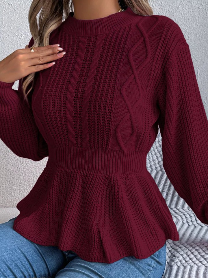 Close-up of the burgundy cable knit panel and fitted waist of the peplum sweater