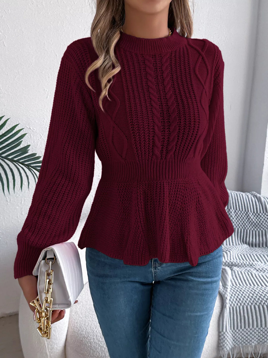 Burgundy peplum hem sweater styled with blue jeans and a white chain handbag