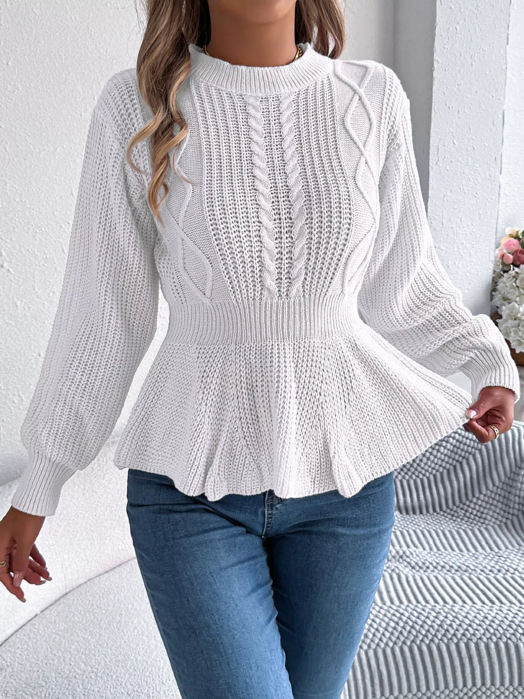 White peplum hem sweater with a hand lifting the ruffle, full length
