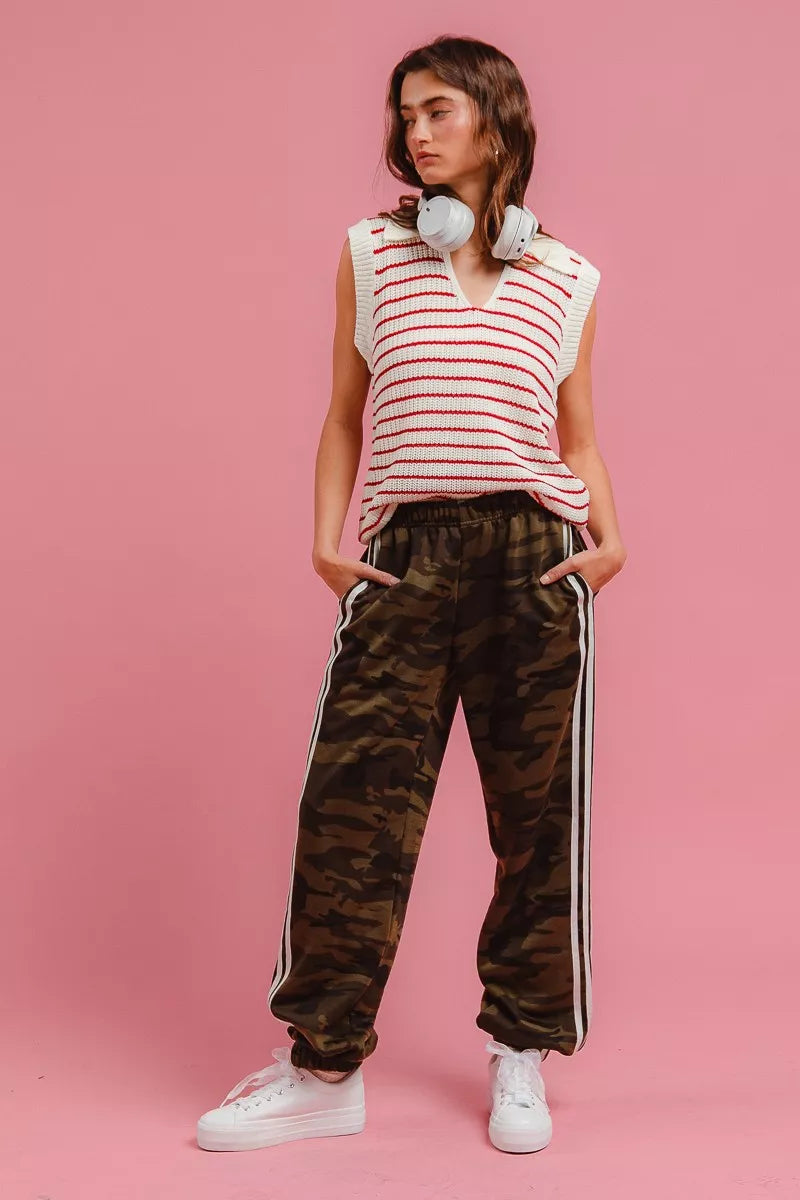 Camo pants with side stripes, model standing with hands in pockets