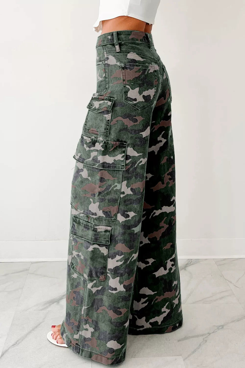 Side view of the green camo cargo pants showing the large pocket and long leg