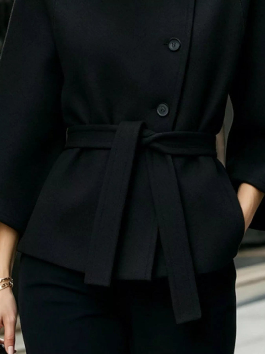Asymmetric button tie belt stand collar in black, close-up detail