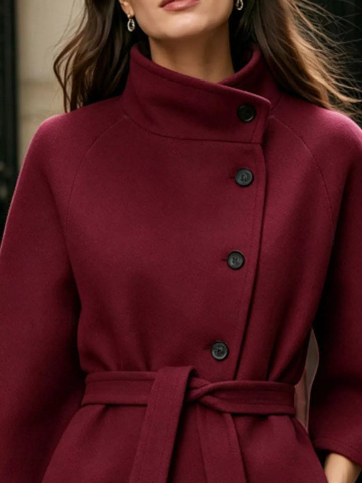 Asymmetric button tie belt stand collar in burgundy, close-up detail