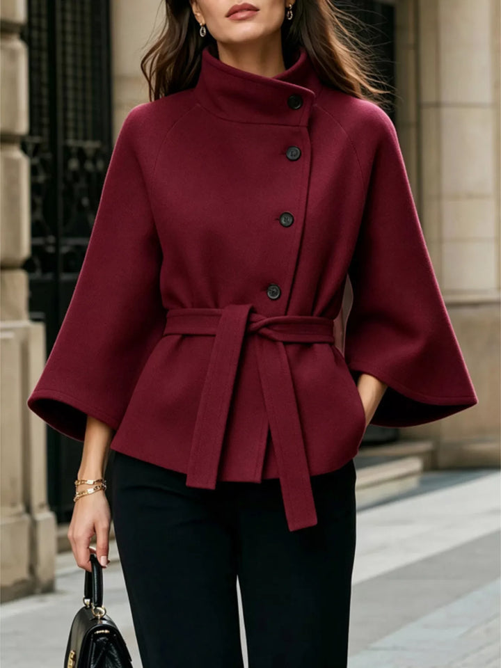Asymmetric button tie belt stand collar in burgundy, front view