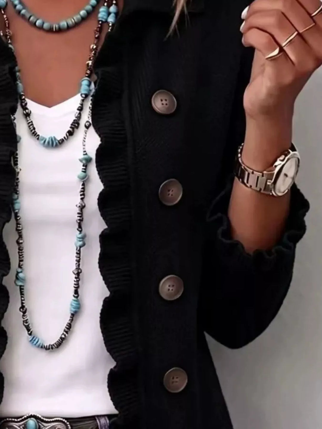 Black ruffle trim cardigan close-up of the buttons and layered necklaces