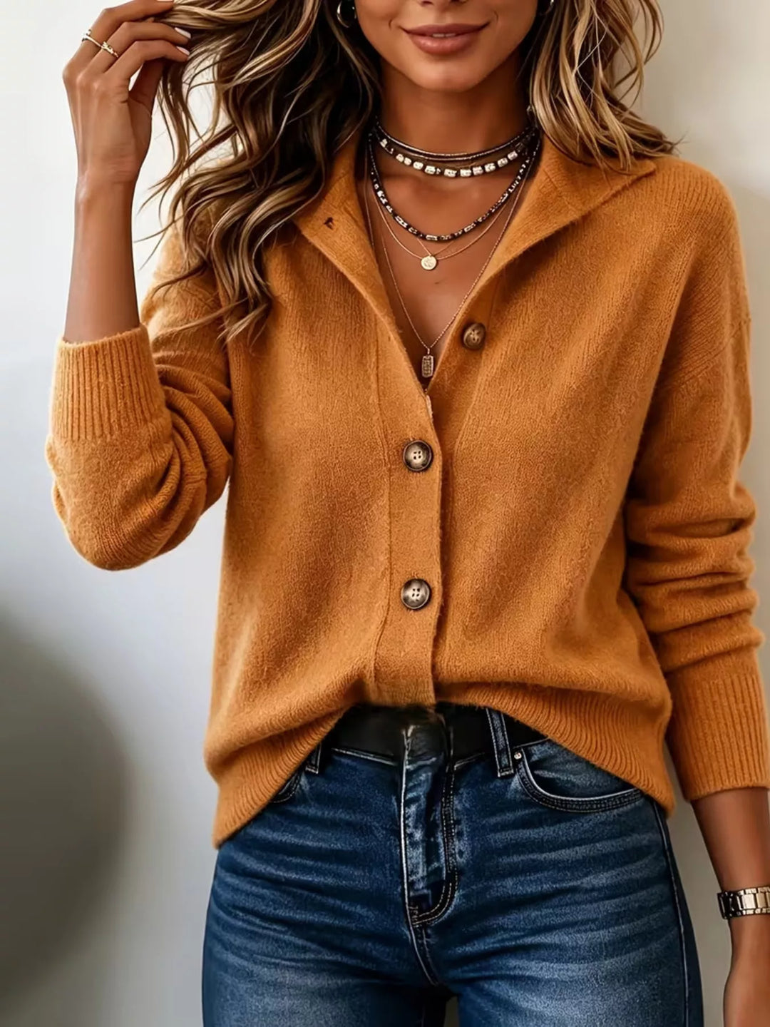 Women's burnt orange cardigan with collared V neck and button front, styled with jeans