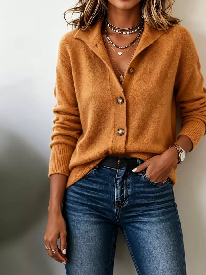Burnt orange collared cardigan worn with hand in jeans pocket