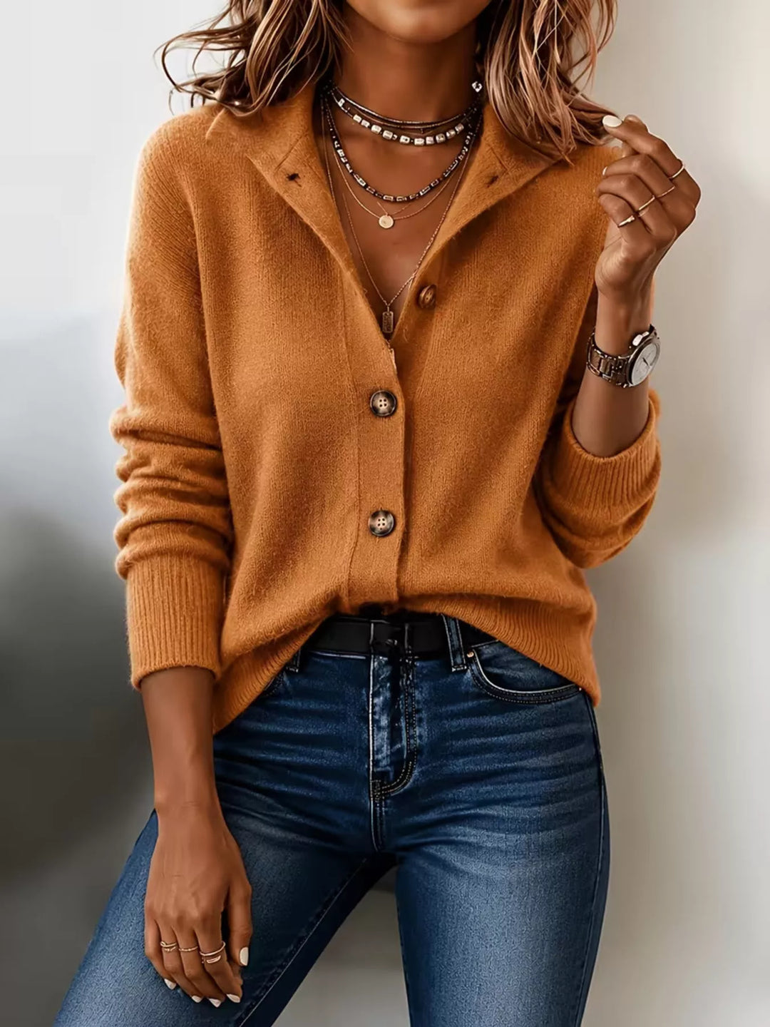 Burnt orange button front knit cardigan with hand at the collar
