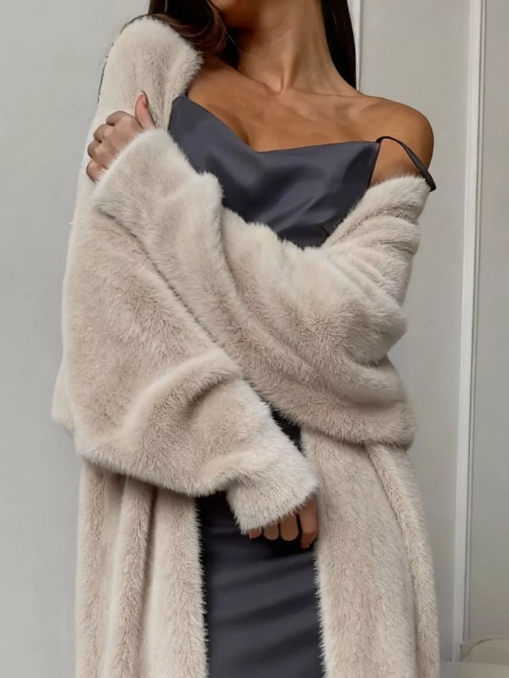 Close-up of beige fuzzy cardigan wrapped around the body with a soft texture