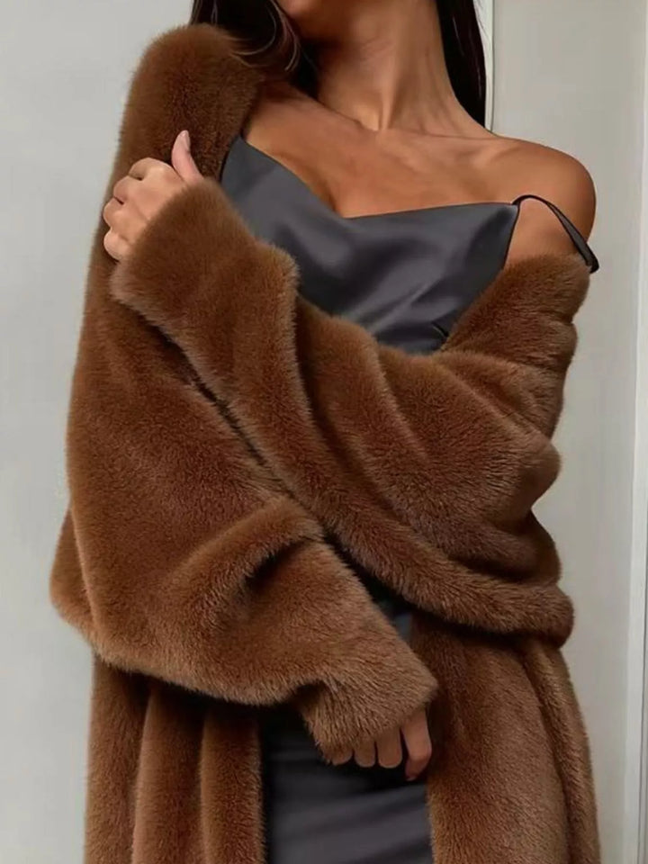 Close-up of chocolate fuzzy cardigan draped over one shoulder with hand at the chest