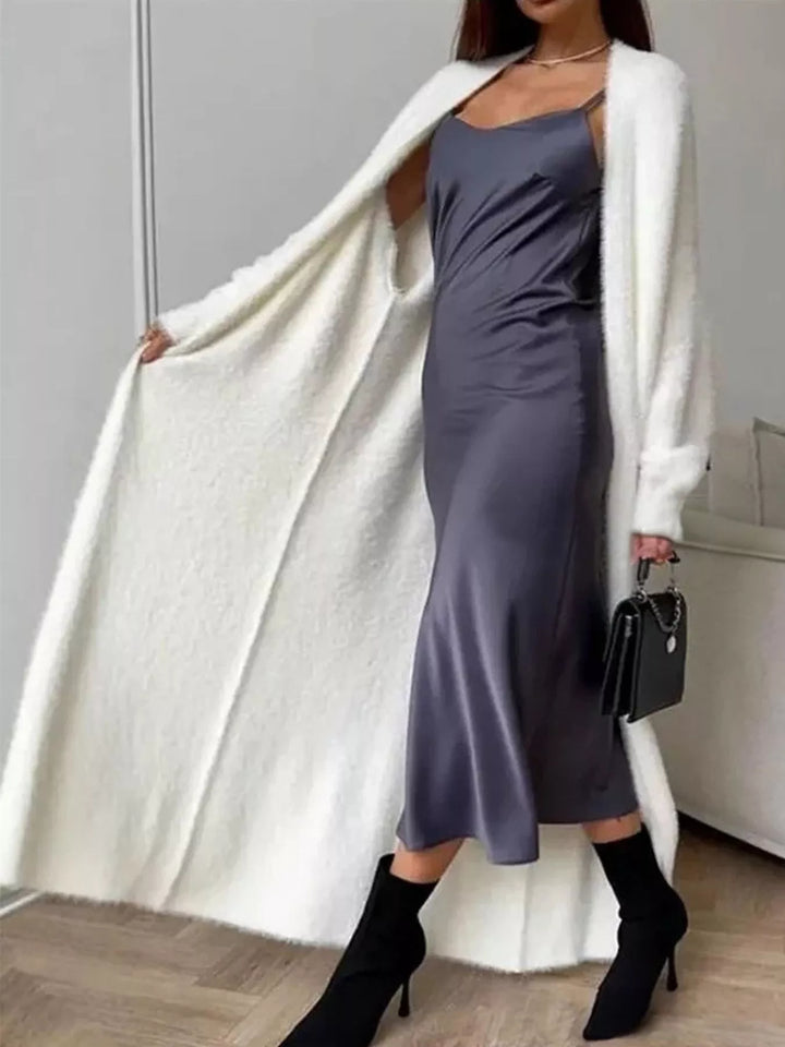 Ivory longline cardigan flowing open, styled with a small black handbag and boots