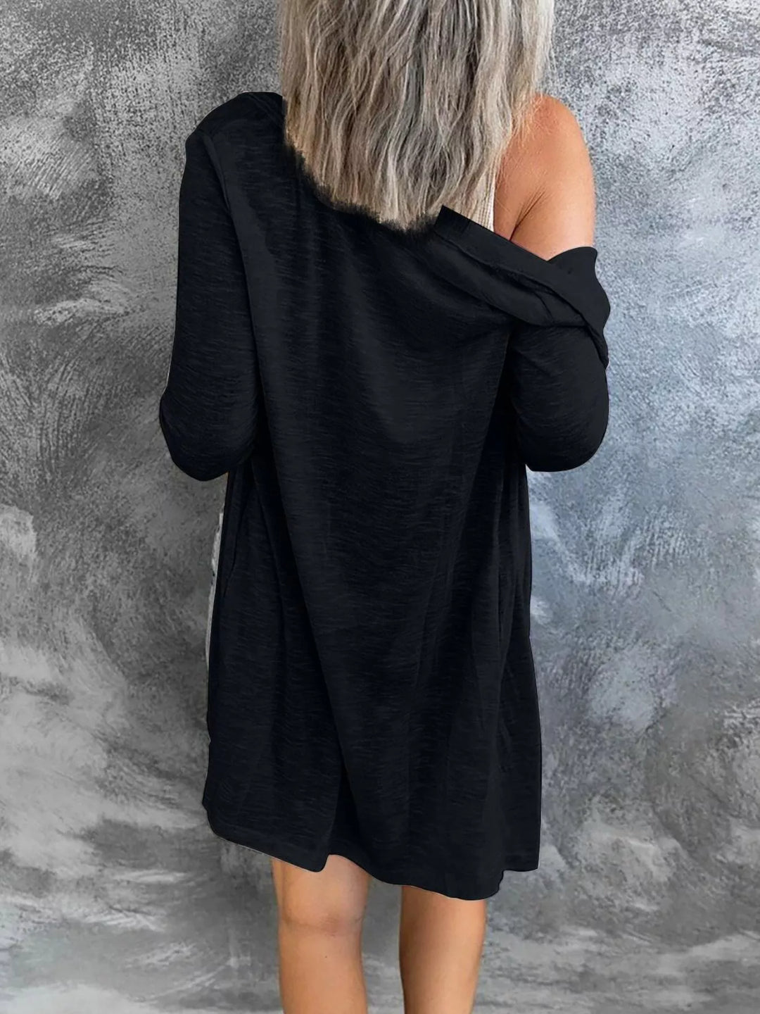 Black longline cardigan from the back with an off the shoulder drape