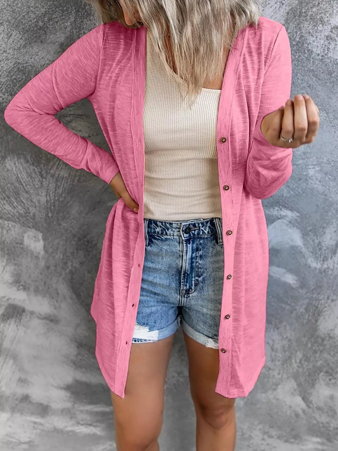 pink longline button front cardigan styled over a tank top and denim shorts