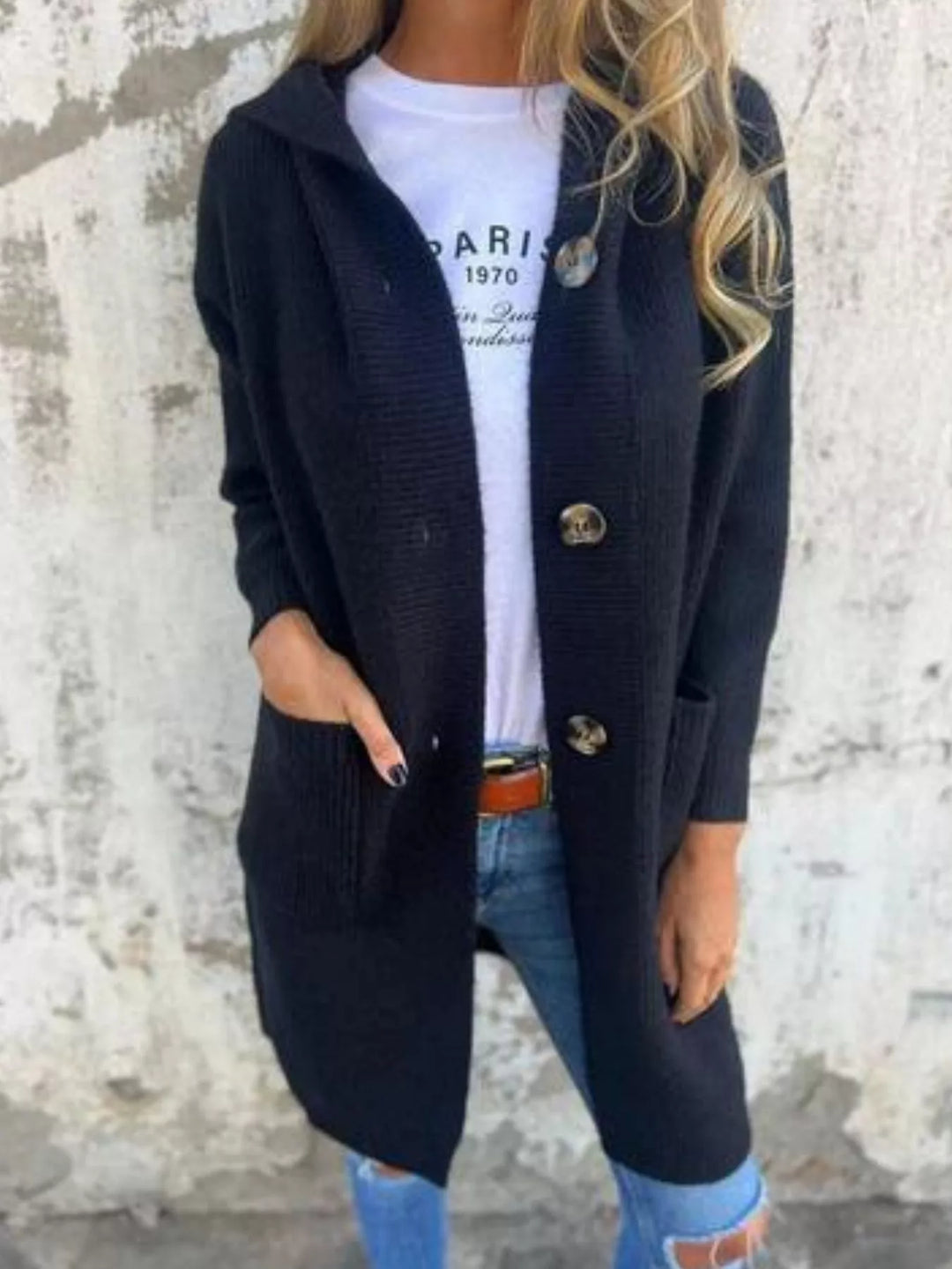 Black chunky knit cardigan worn with hands in the front pockets