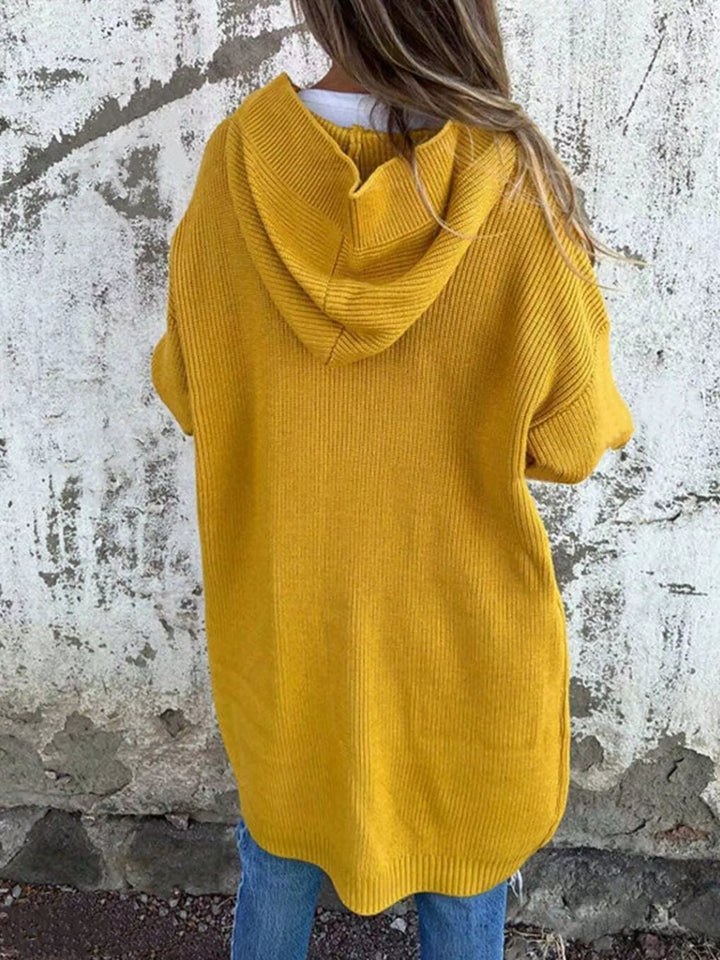 Back view of the mustard cardigan with a large hood and relaxed length