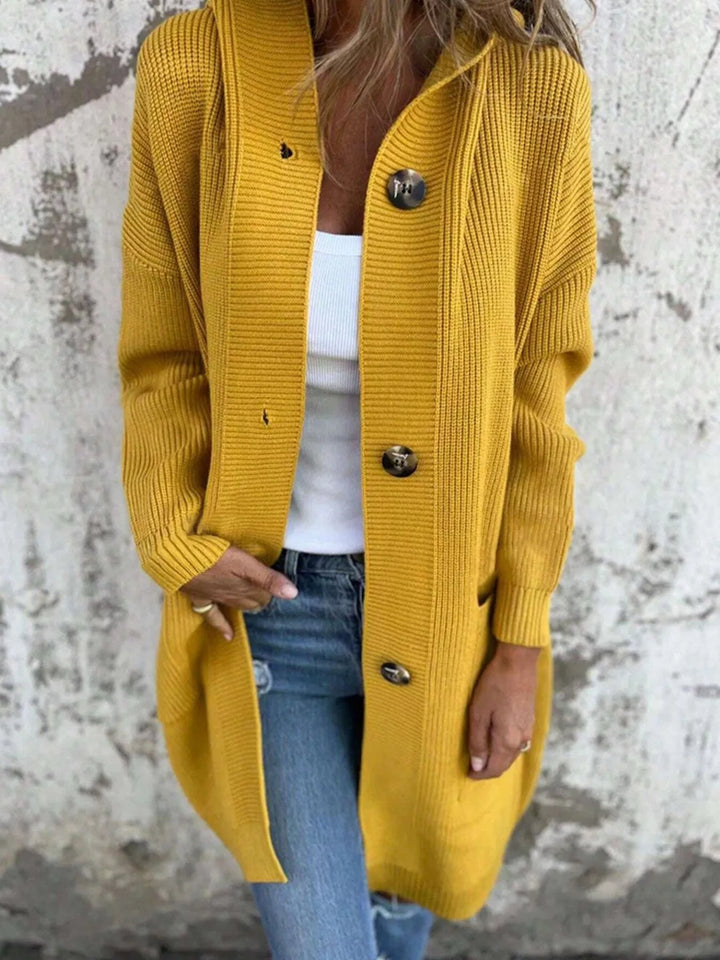 Mustard chunky knit cardigan styled open over a white top and jeans
