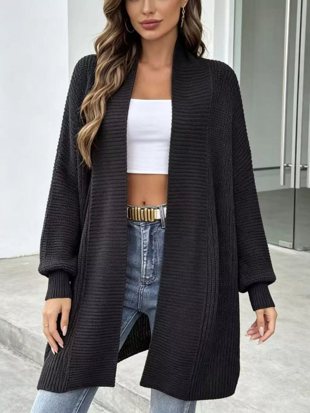 Black long cardigan with ribbed shawl collar worn open with jeans and a belt