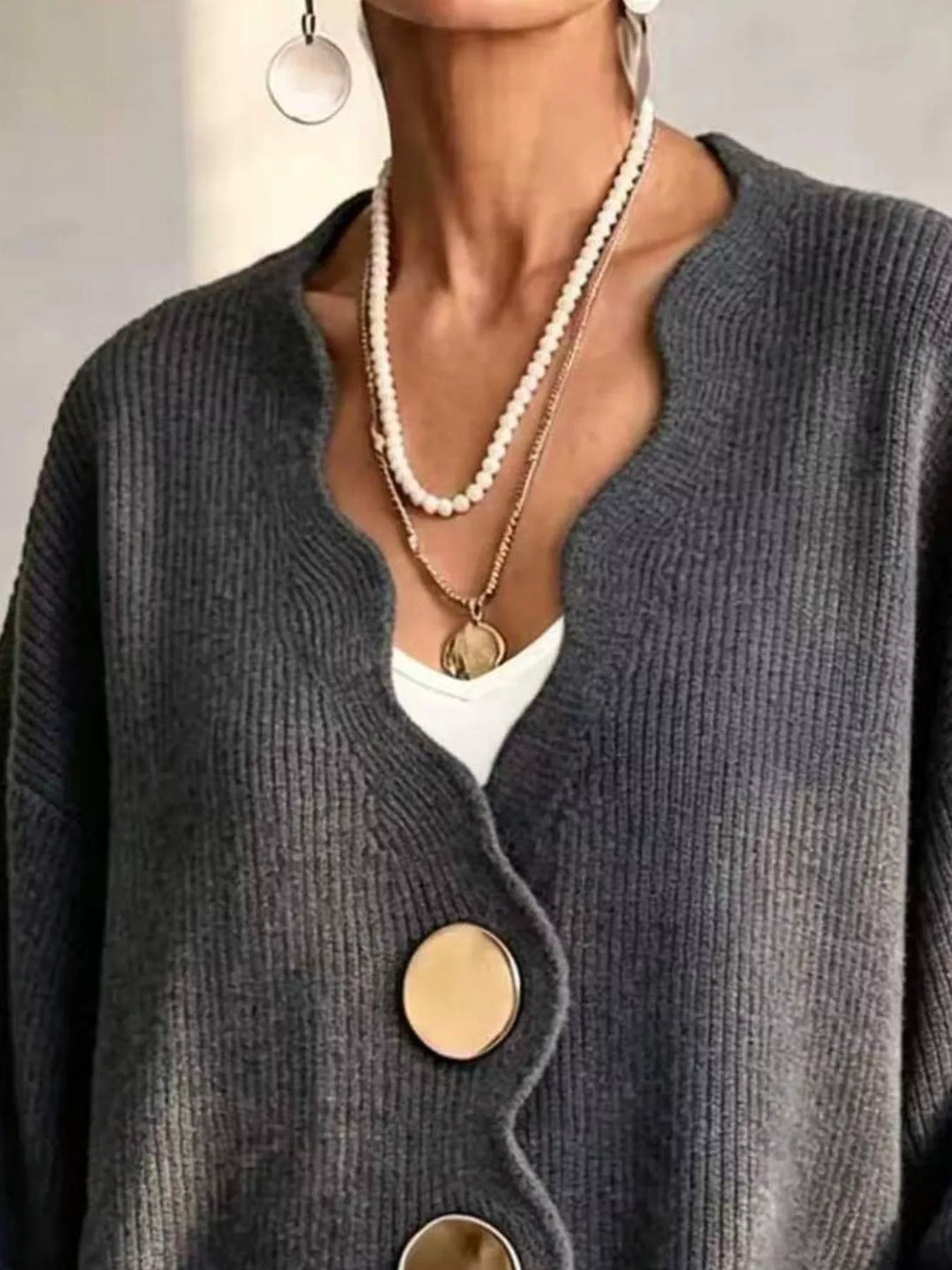 Close-up of the charcoal cardigan wavy neckline layered with pearl necklaces