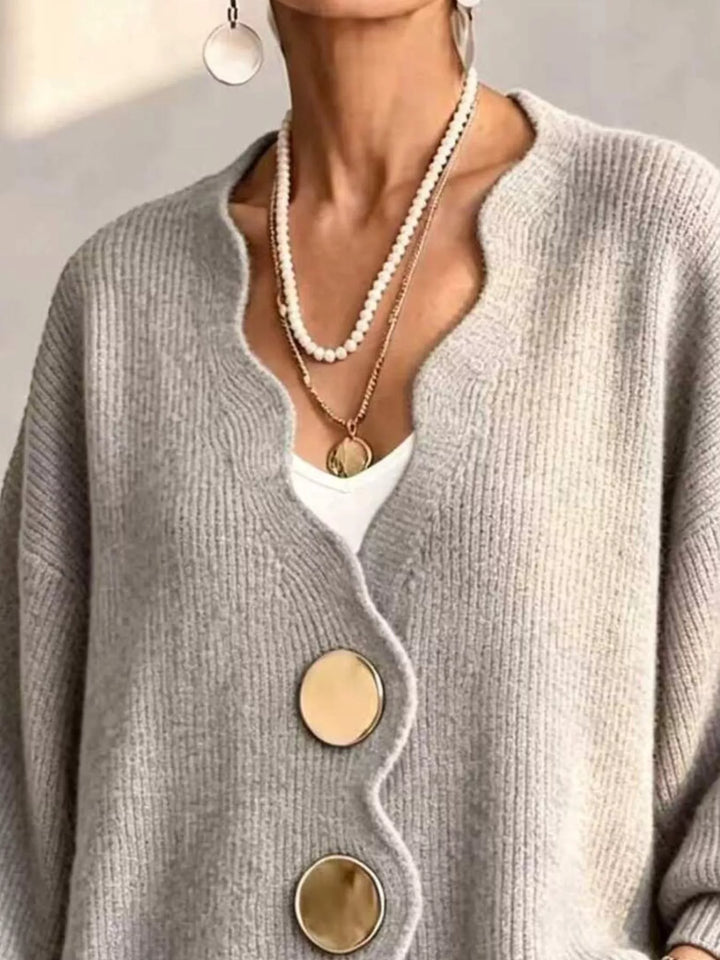 Close-up of the light gray cardigan wavy neckline layered with pearl necklaces