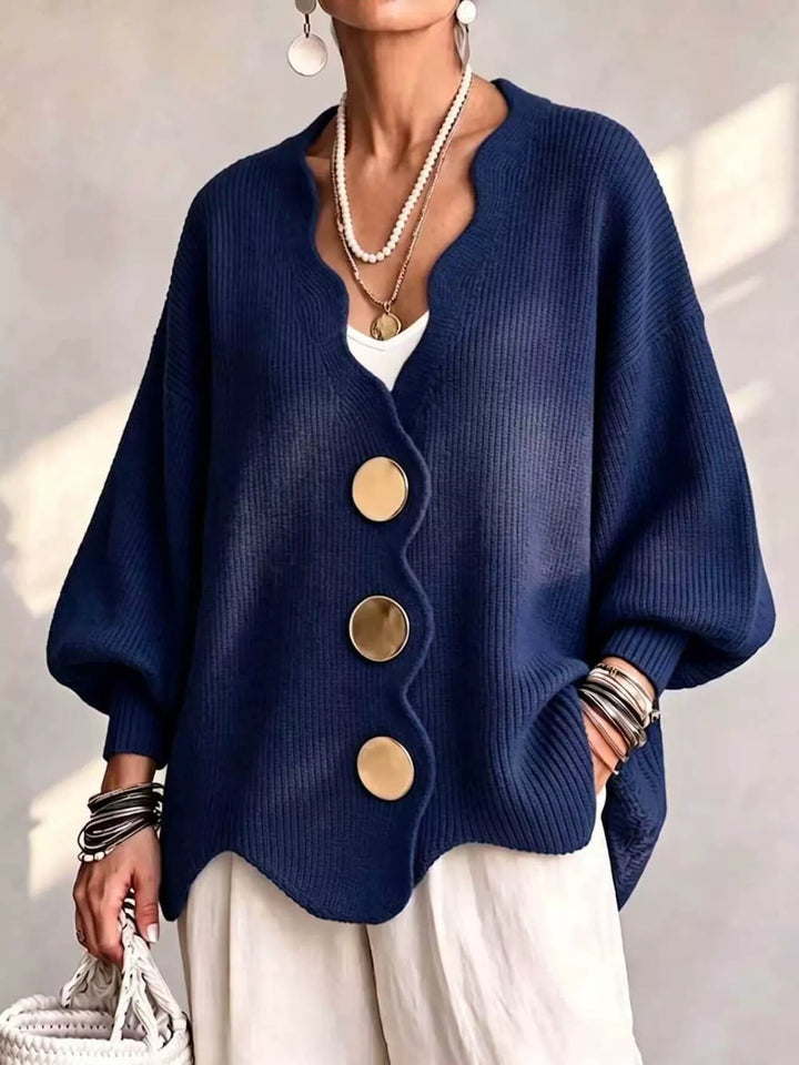 Oversized scalloped edge cardigan in navy with gold buttons, worn over white pants