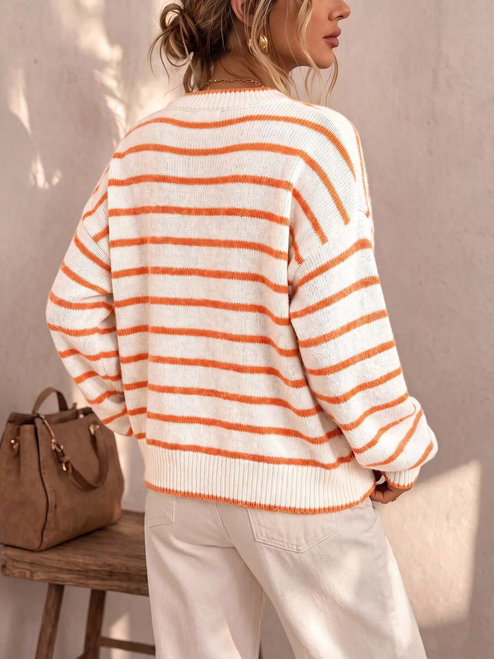 Back view of the ivory striped crew neck cardigan with a brown bag nearby