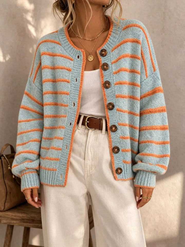 Front view of the light blue striped button cardigan with brown belt and white pants