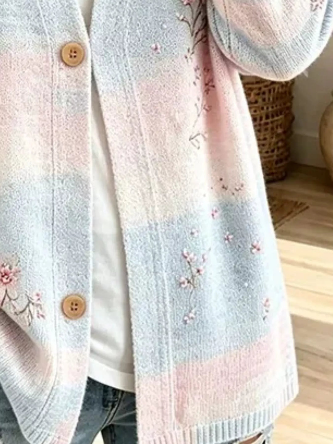 Close-up of pastel blue cardigan soft color blocks and small floral embroidery
