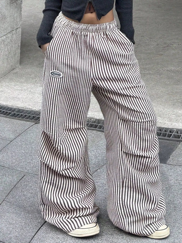 Brown pinstripe cargo pants, angled side view with white sneakers
