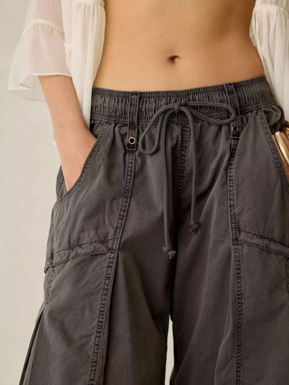 Close-up of charcoal cargo pants drawstring waist and large side pocket