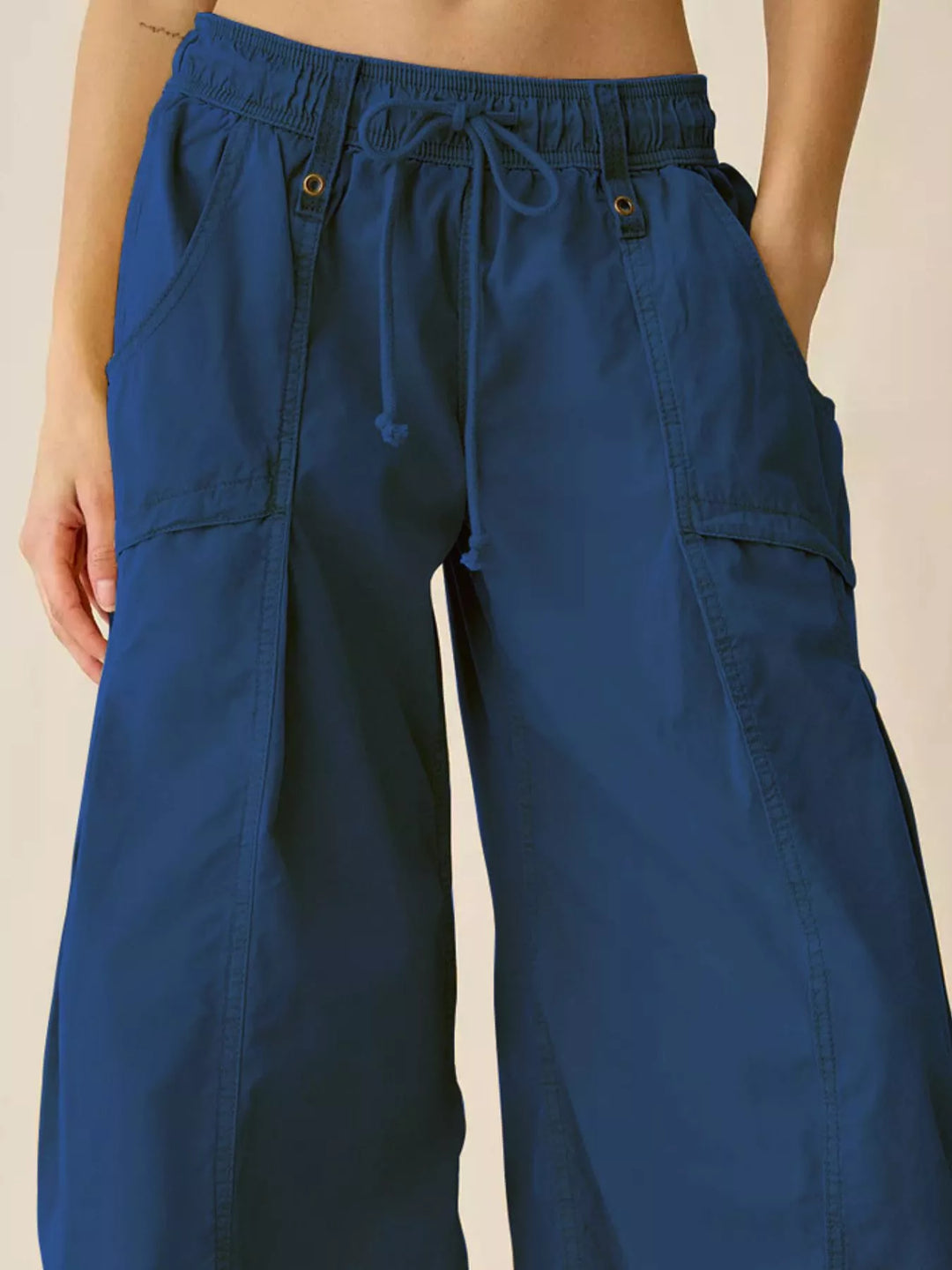 Close-up of cobalt blue cargo pants waistband and side pocket