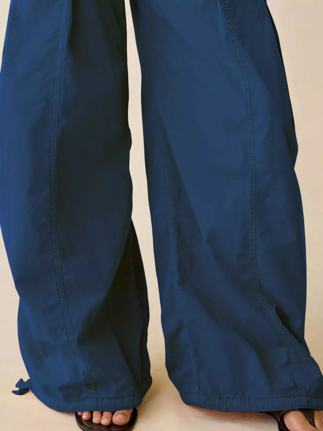 Close-up of cobalt blue parachute cargo pants wide leg hem with drawstring
