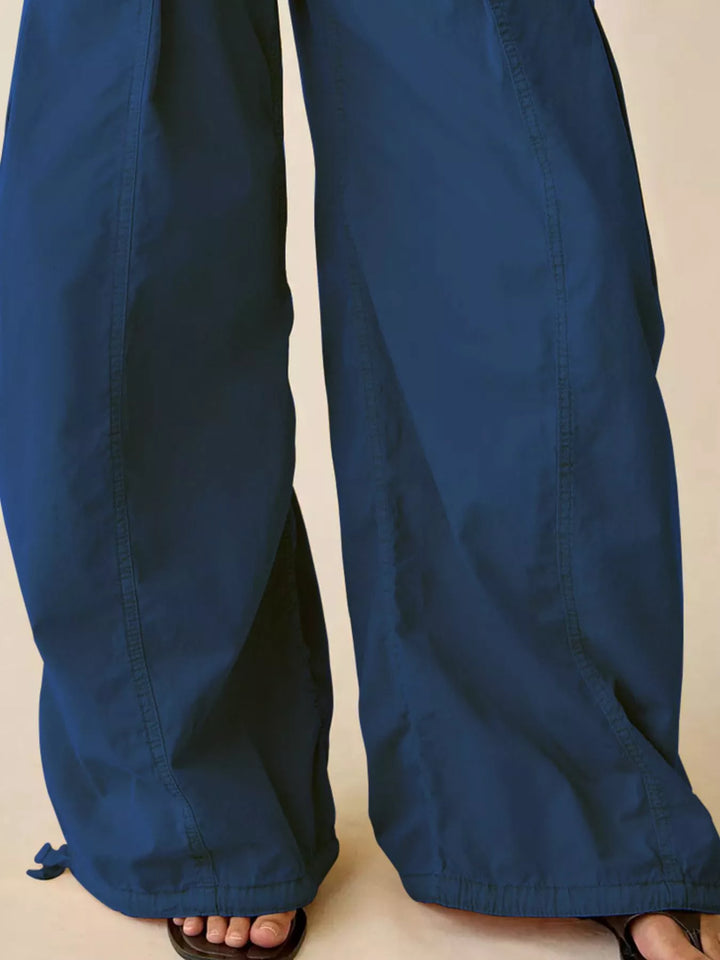 Close-up of cobalt blue parachute cargo pants wide leg hem with drawstring
