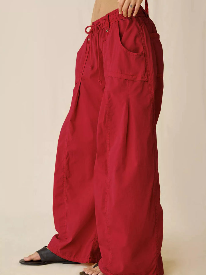 Red cargo pants in side view with sandals, showing the wide leg shape