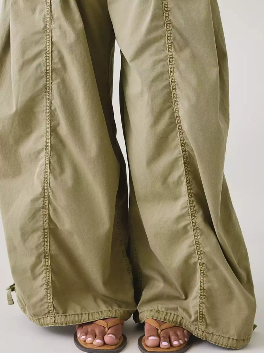 Close-up of sage parachute cargo pants wide leg hem with sandals