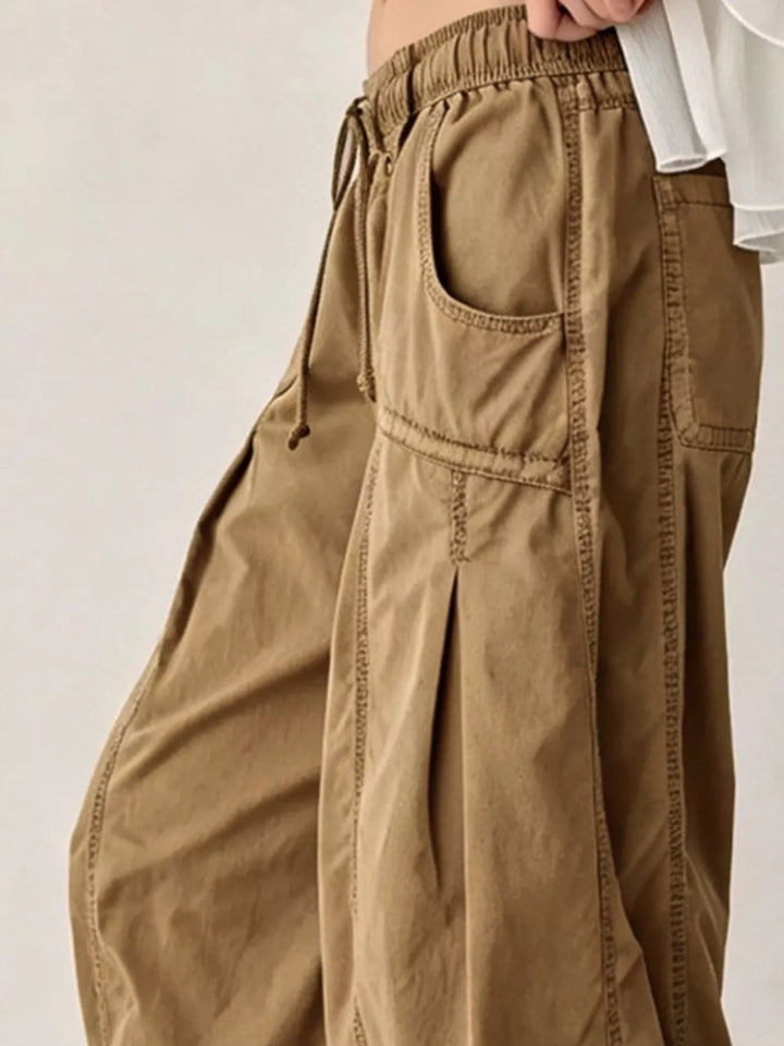 Tan cargo pants in side view with deep pocket and wide leg