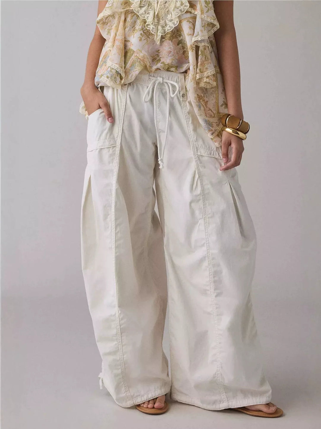 White wide leg parachute cargo pants with drawstring waist, front view