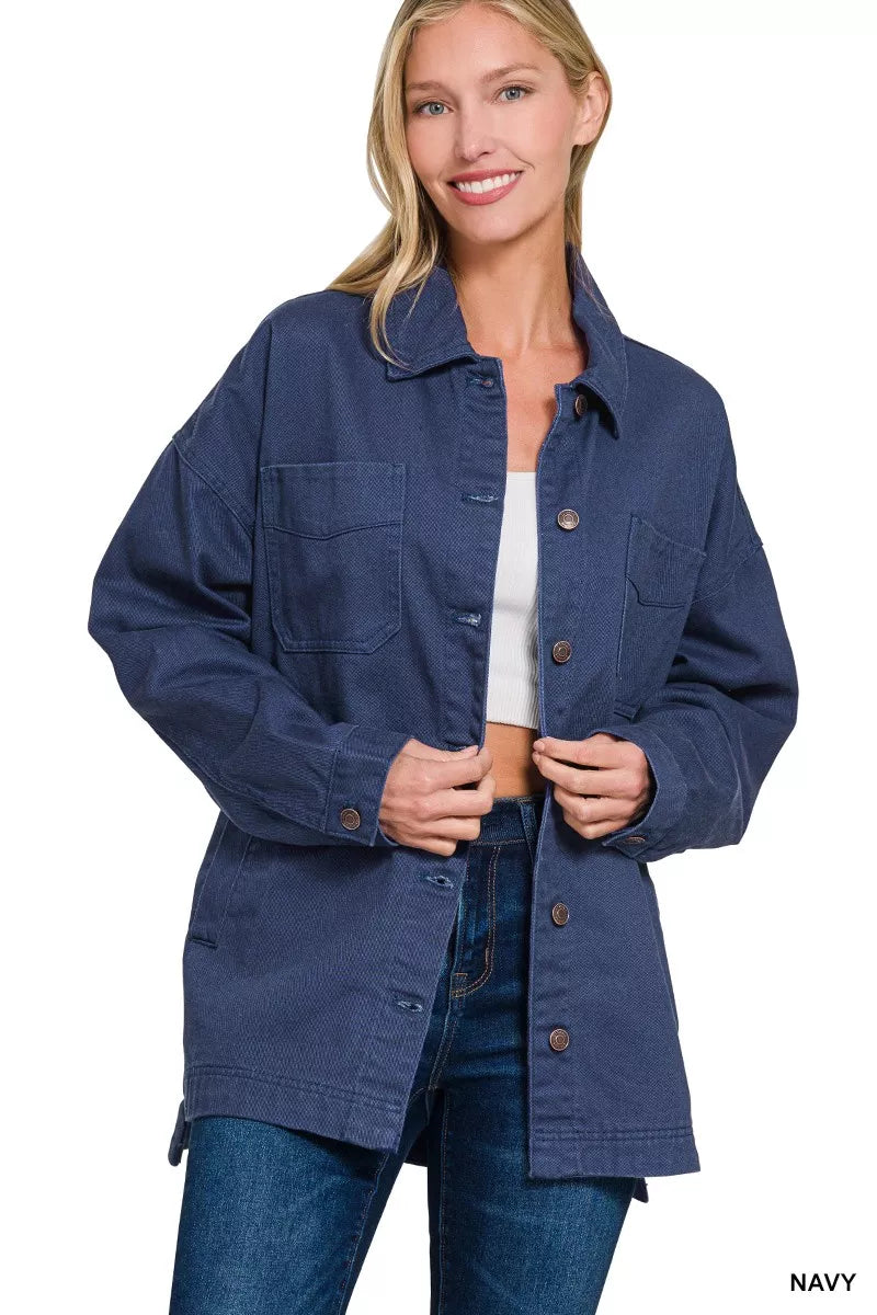 Navy button front shacket worn open over a white top and dark jeans