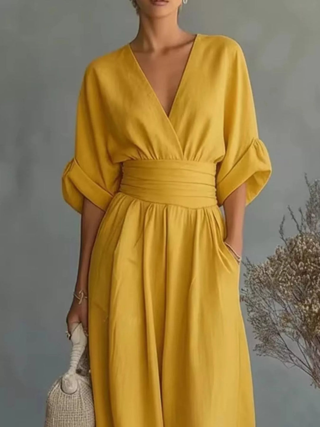Close-up of the mustard wrap jumpsuit with cinched waist and pocket