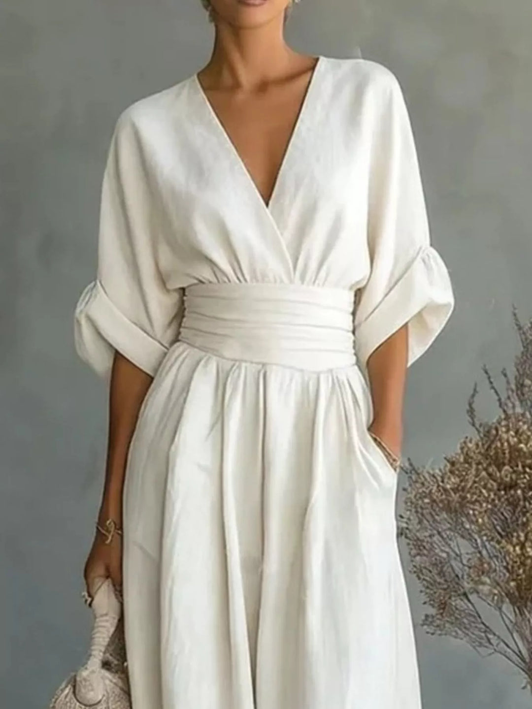 Close-up of the white wrap jumpsuit with a gathered waist and pocket