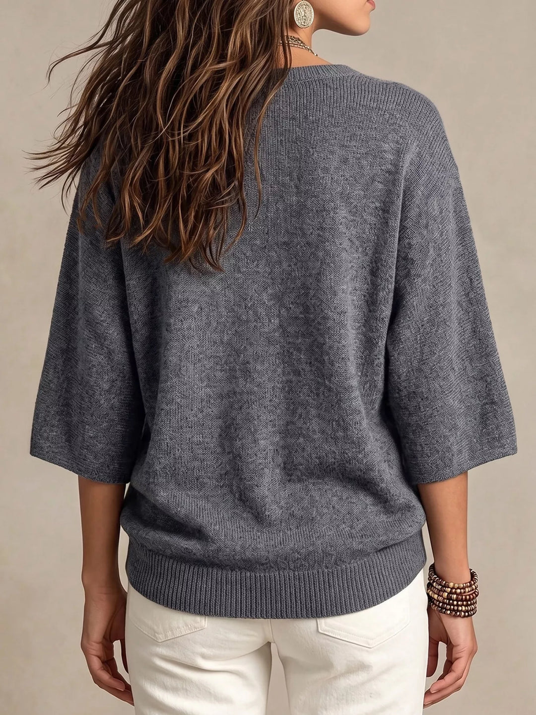 Back view of the gray lightweight knit top with ribbed hem